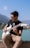 Close-up of Patrick strumming his acoustic guitar with Lake Tahoe’s blue waters in the background.