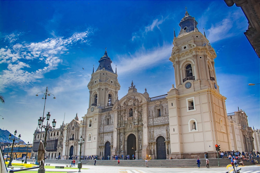 Edificio de hormigón beige bajo el cielo azul y las nubes blancas durante el día