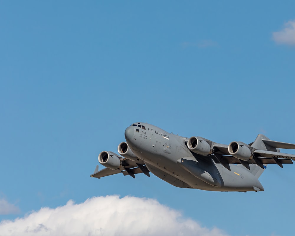 avião a jato cinza e preto no ar durante o dia