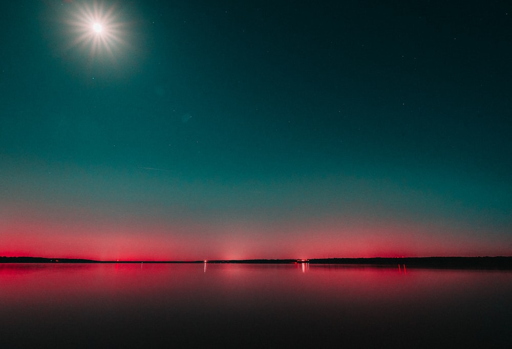 luz azul y naranja en un cielo azul sobre un lago