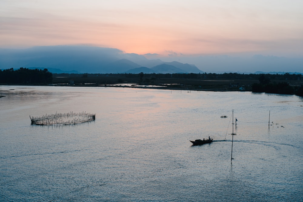 silhouette of boat on sea during sunset