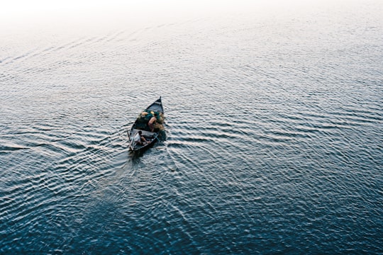 person riding on black kayak on body of water during daytime in Hoi An Vietnam