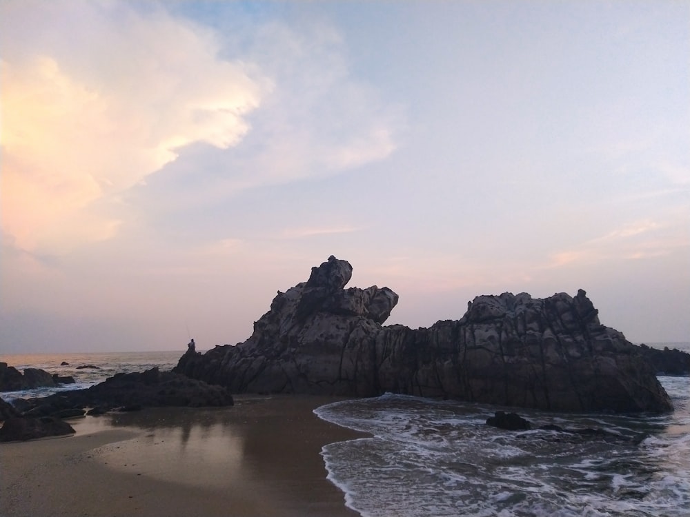 gray rocky mountain on seashore during daytime