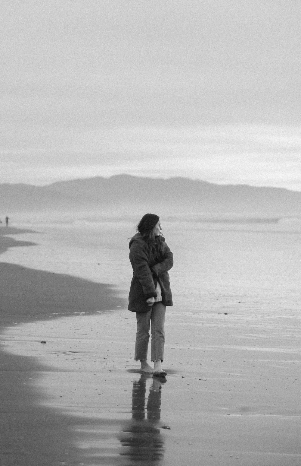grayscale photo of man and woman walking on beach