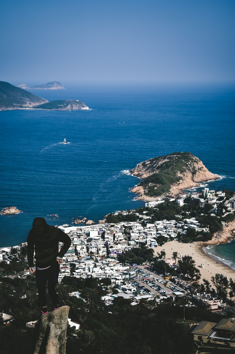 man in black jacket standing on the seashore during daytime