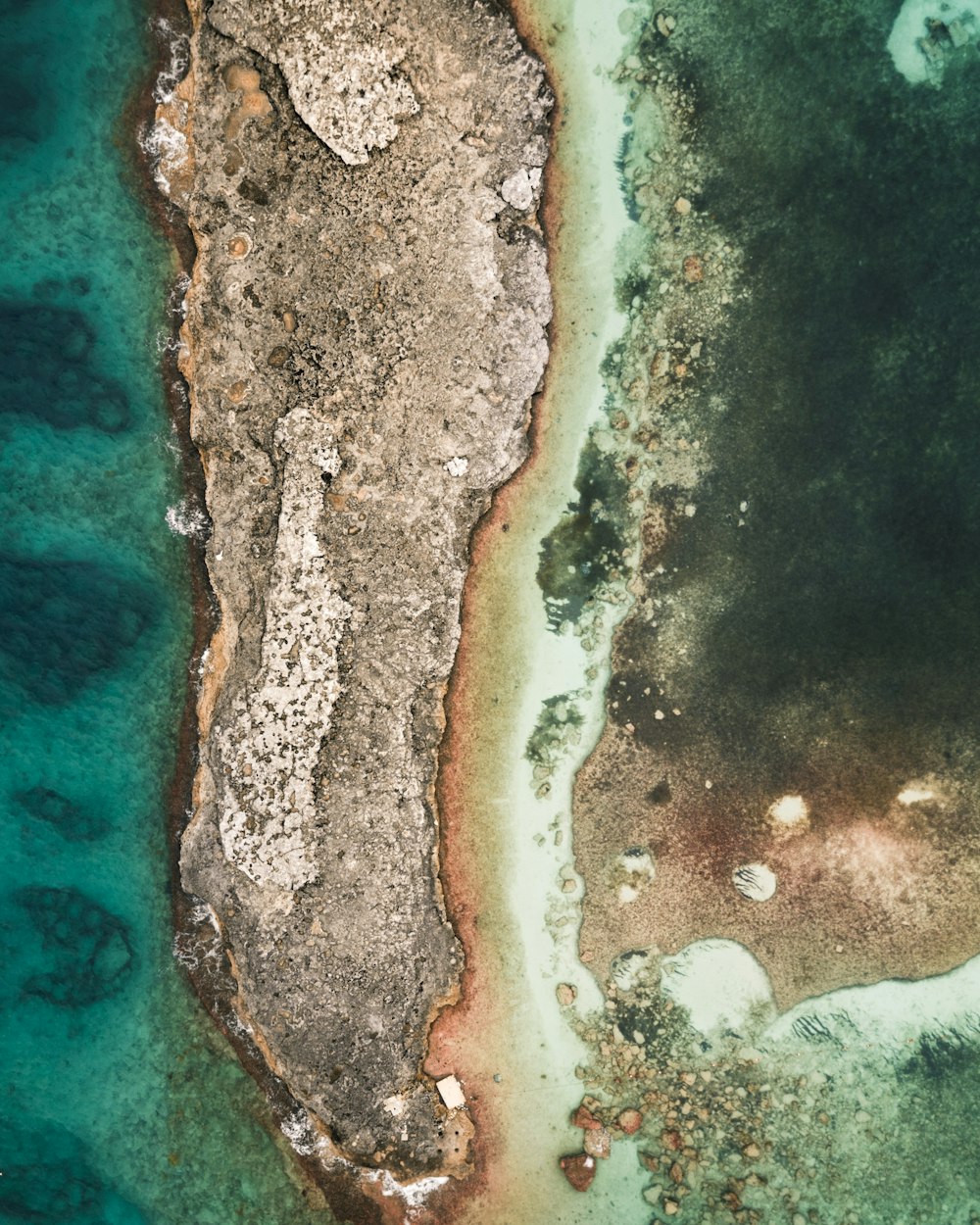 brown and black rock formation on body of water