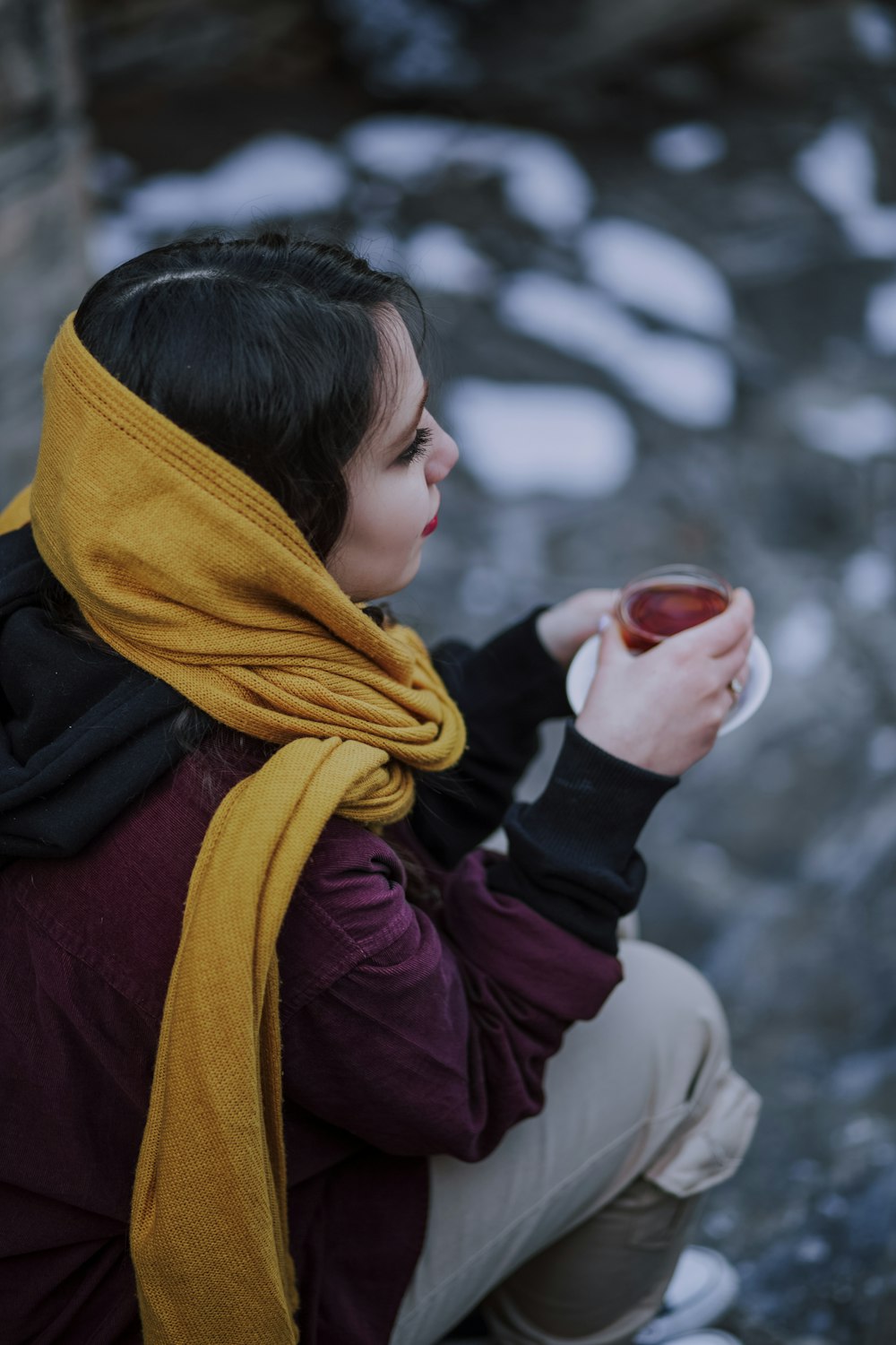 mujer con pañuelo púrpura sosteniendo una copa roja