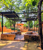 An inviting outdoor seating area shaded by a pergola entwined with climbing vines.