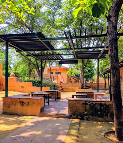 Outdoor patio with natural stone floors and comfortable seating under a wooden pergola.