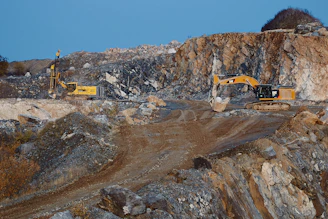 yellow and black excavator on brown rocky mountain during daytime