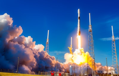 white and red space ship on blue sky during daytime launch day teams background