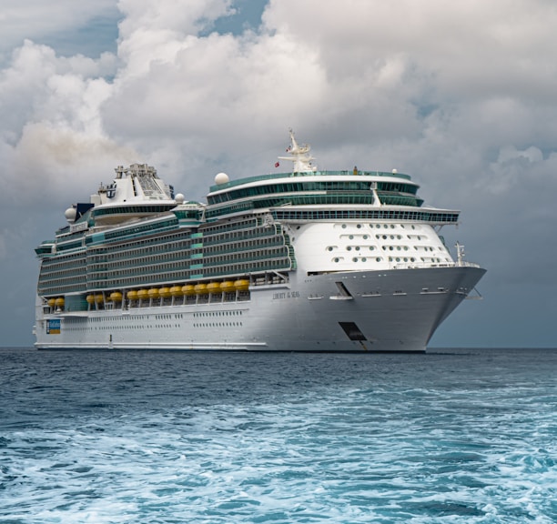 white cruise ship on sea under white clouds and blue sky during daytime