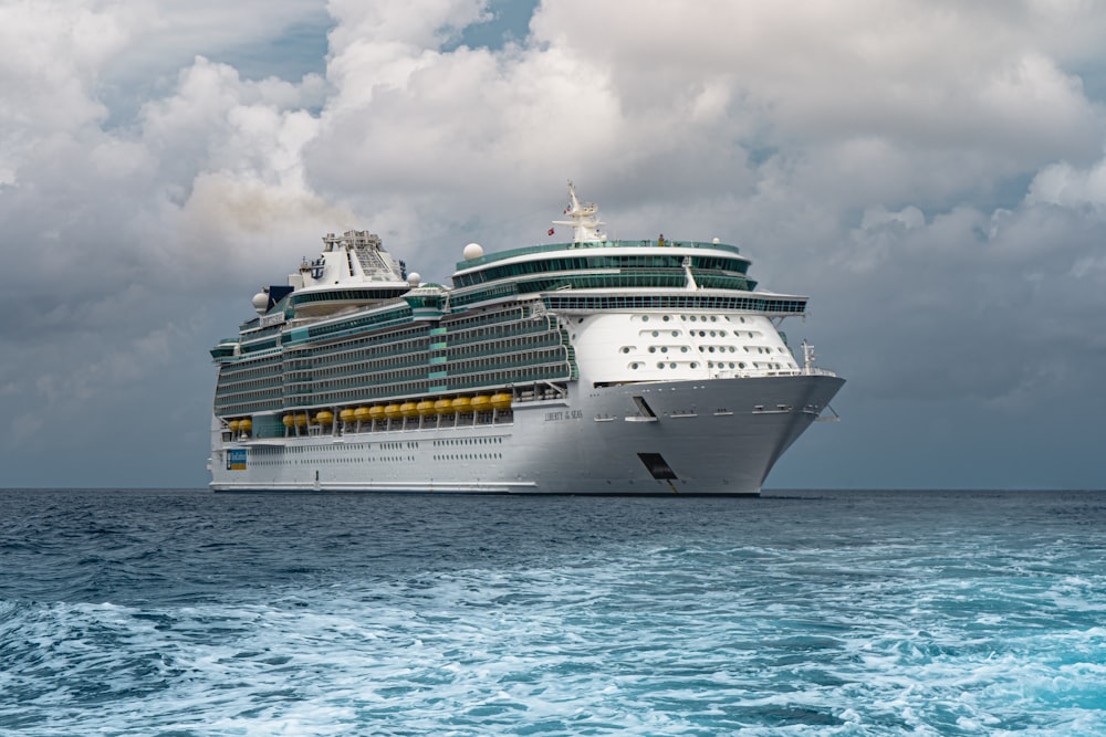 white cruise ship on sea under white clouds and blue sky during daytime