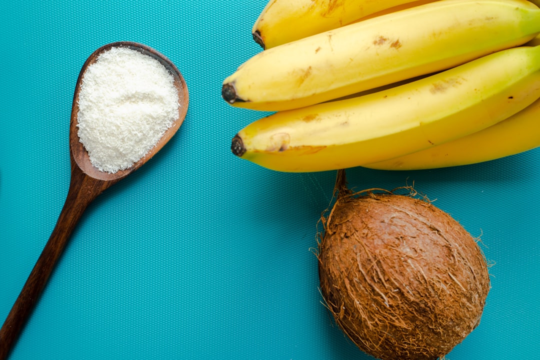 yellow banana fruit beside brown round fruit