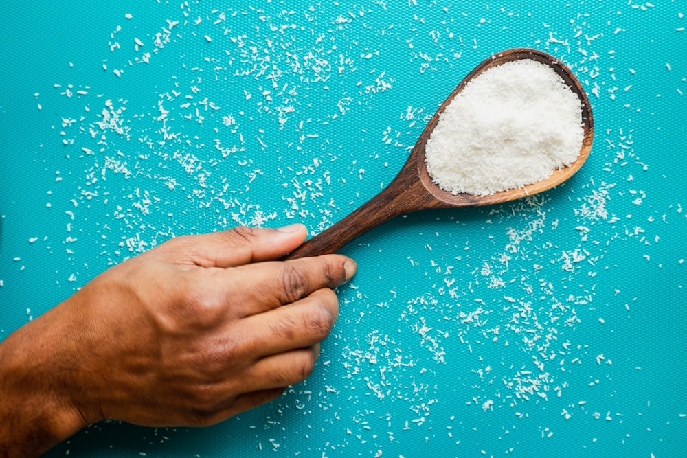 person holding brown wooden spoon