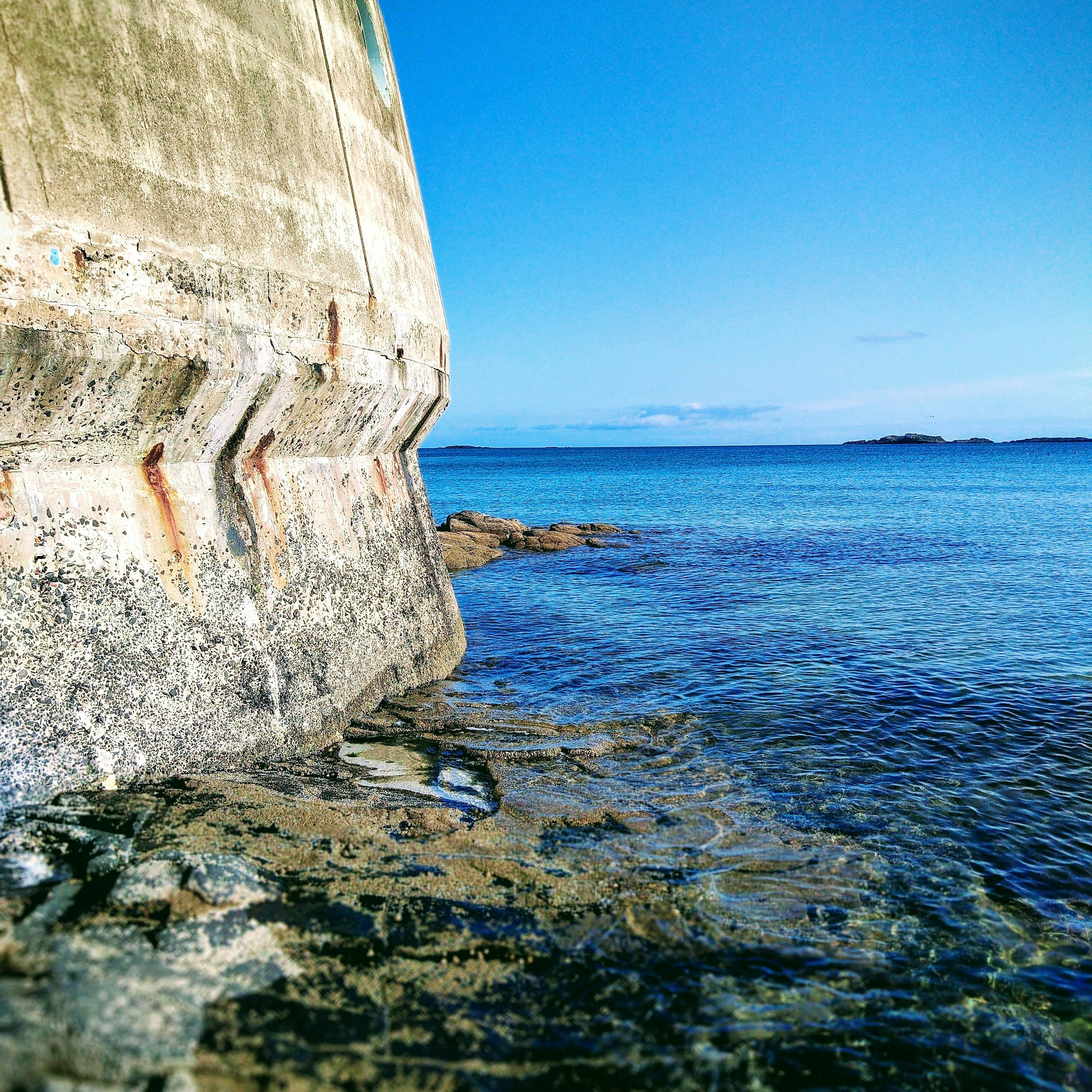 brown rock formation near body of water during daytime