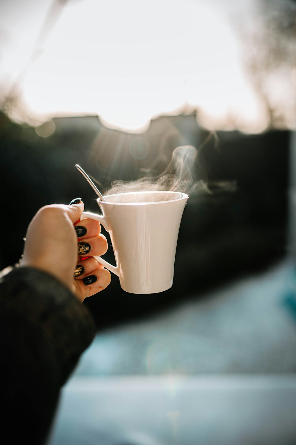 persona sosteniendo una taza de cerámica blanca