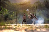 Young players competing in traditional sepak takraw match on village field