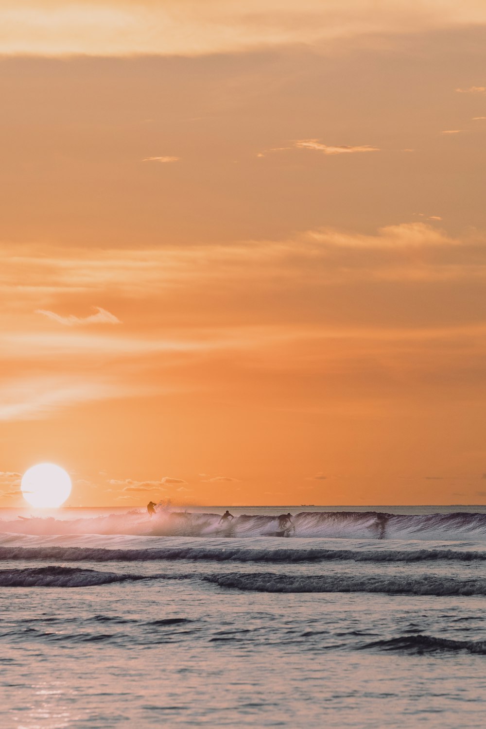 ocean waves crashing on shore during sunset