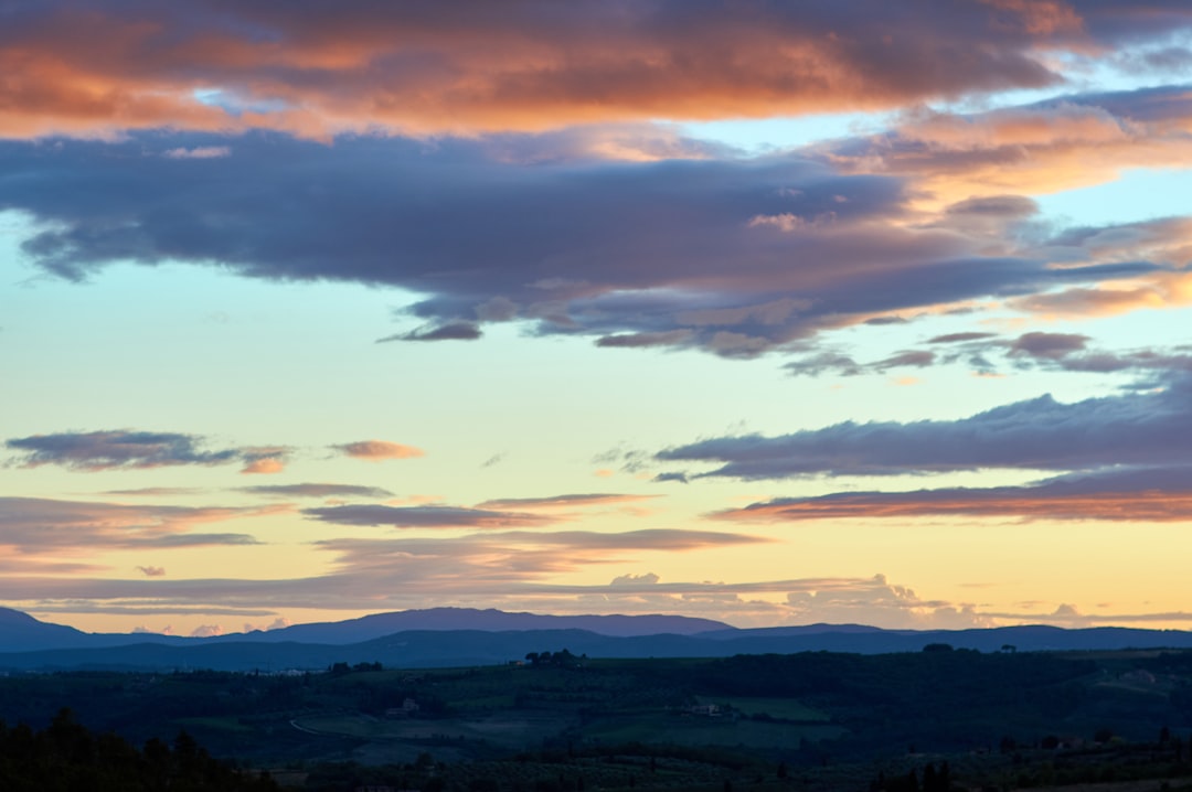 silhouette of mountains under cloudy sky during sunset