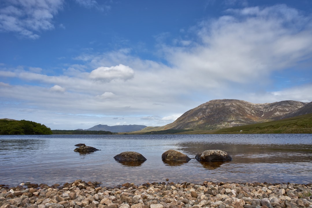 brown rocks on body of water under blue sky during daytime