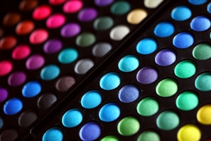 An array of colorful eyeshadows arranged in a palette.
