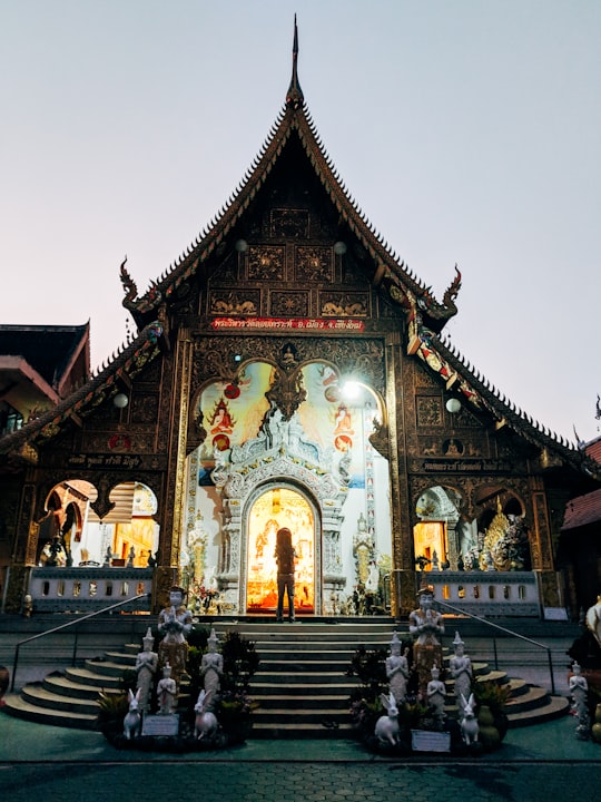 people walking on street near brown and black concrete building during daytime in Wat Loi Khro Thailand