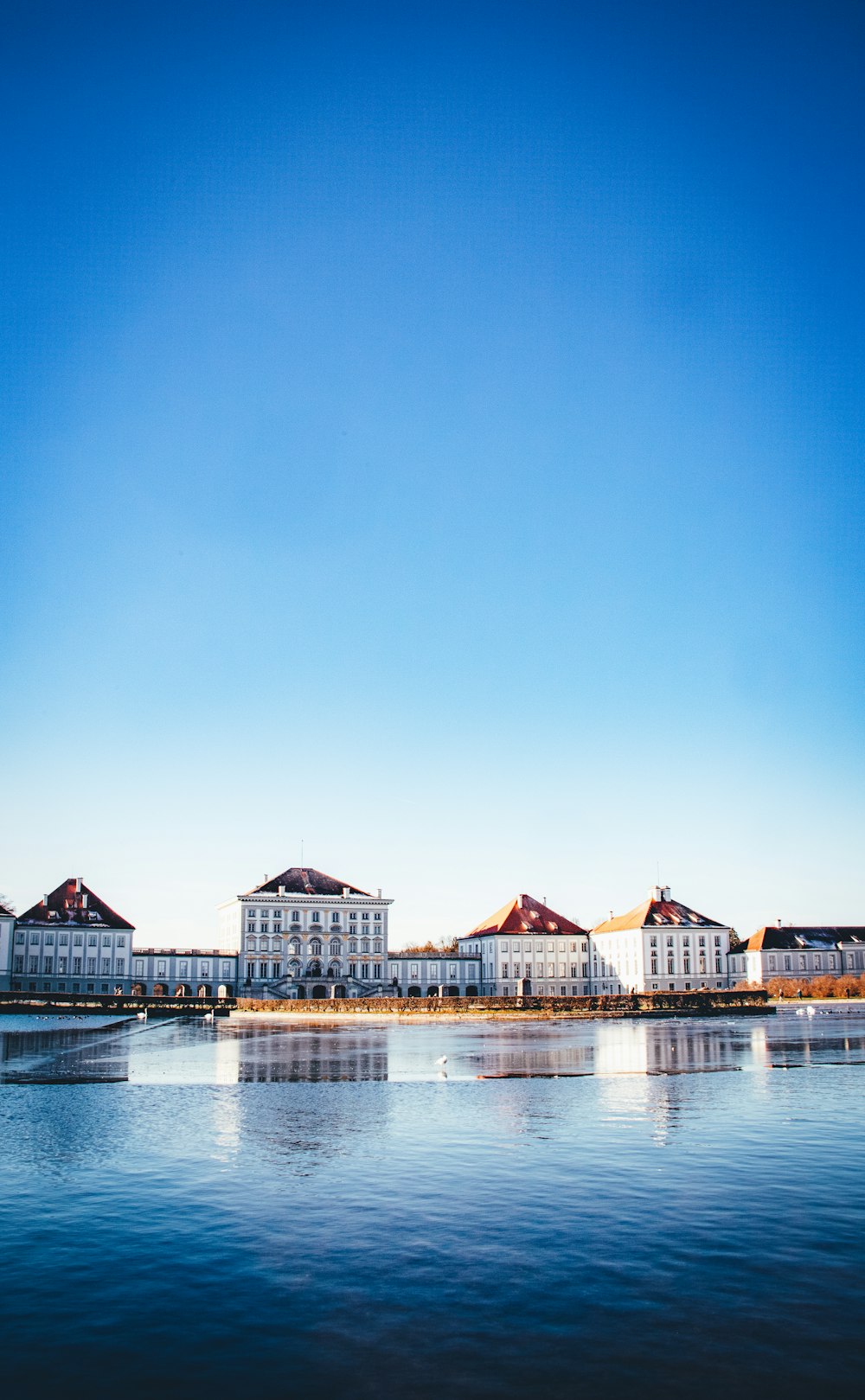 brown and white wooden house on body of water during daytime