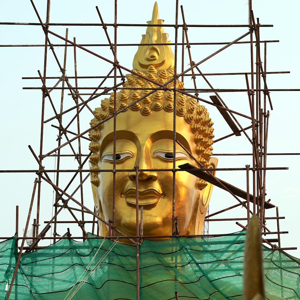gold buddha statue on green textile