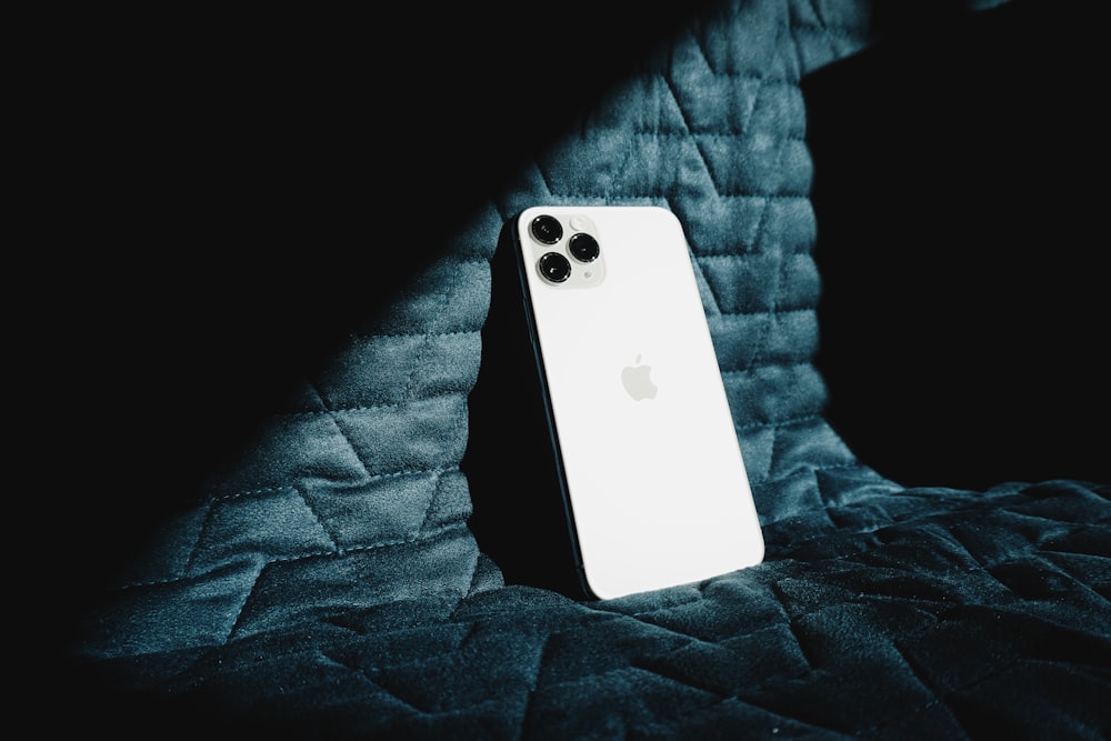 white iphone 5 c on black textile