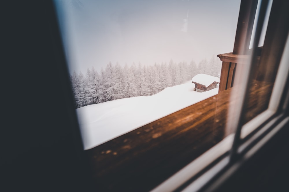 brown wooden house on snow covered ground during daytime