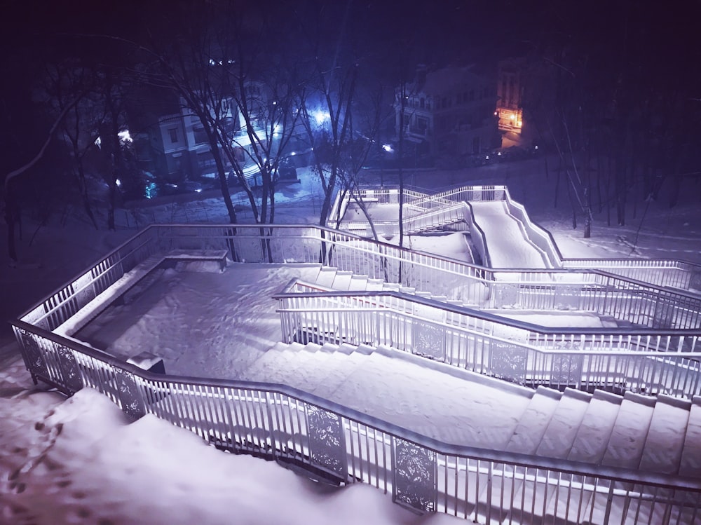 white car on road covered with snow during night time