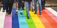 man in black shirt and blue denim jeans walking on purple and yellow carpet