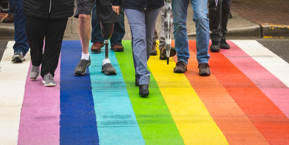 man in black shirt and blue denim jeans walking on purple and yellow carpet