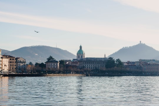 body of water near city buildings during daytime in Como Italy