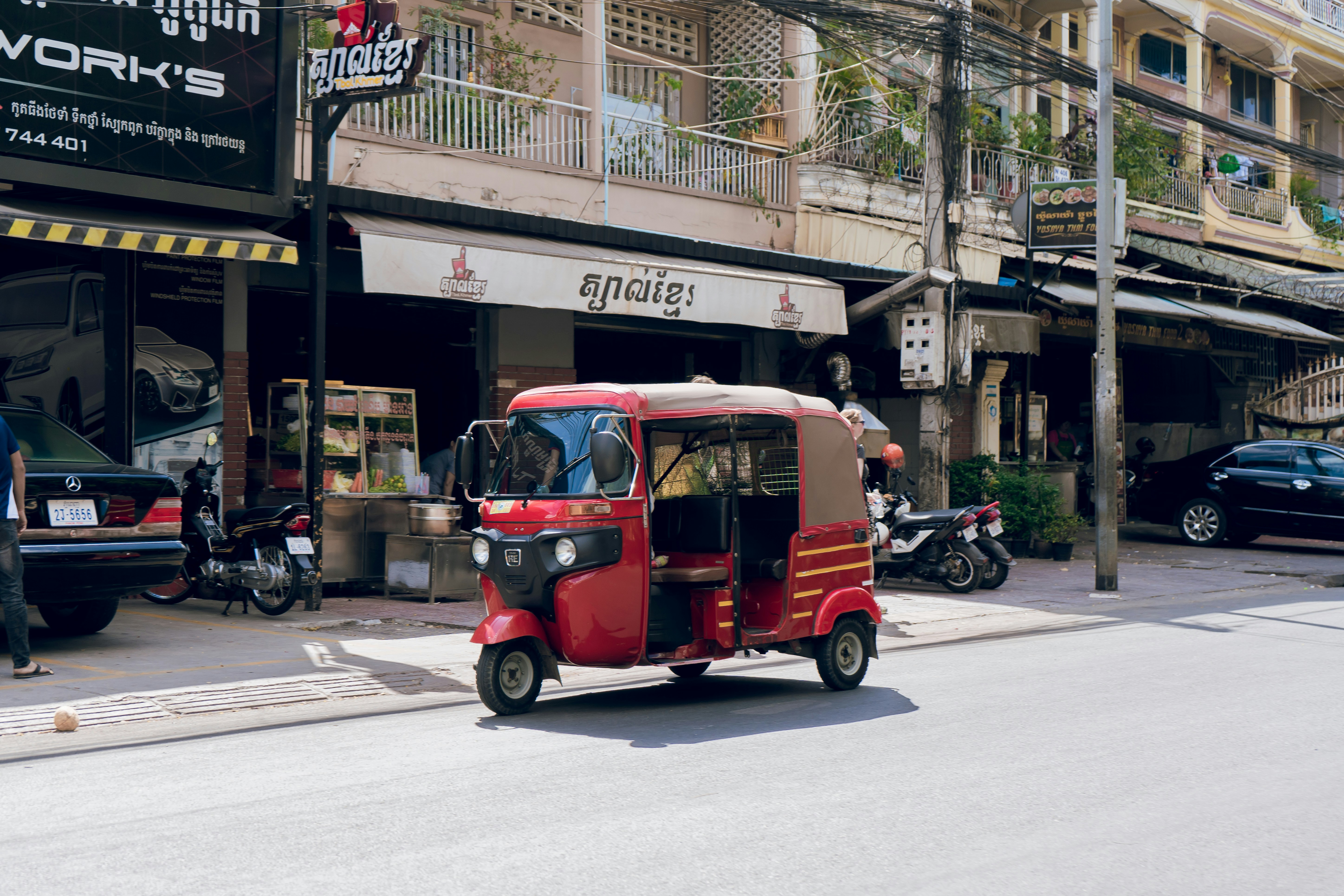 Small electric hatchback driving through a modern city street, highlighting urban-friendly size.
