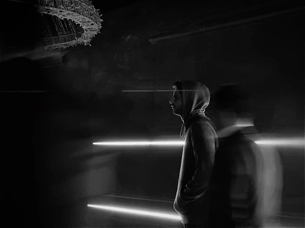 A dynamic model showcasing a sleek black hoodie with AI-generated pattern variations in urban poses.