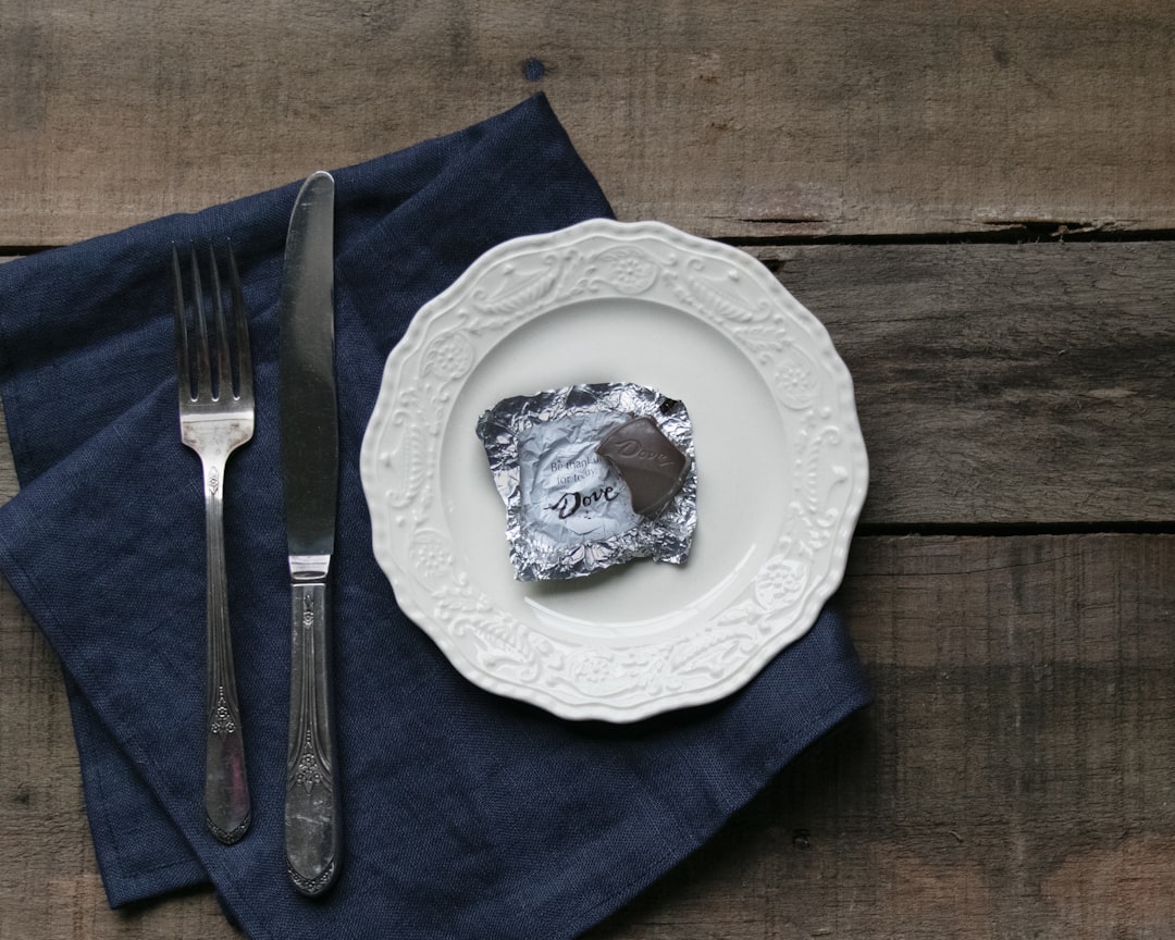 white and blue floral ceramic plate with stainless steel fork and bread knife