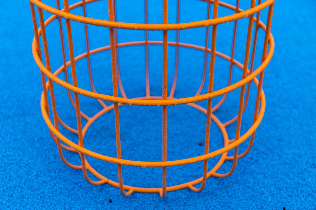 orange metal basket on gray textile