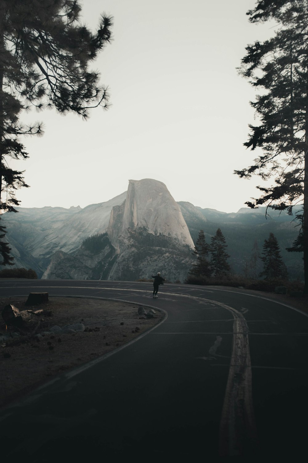 gray concrete road near mountain during daytime