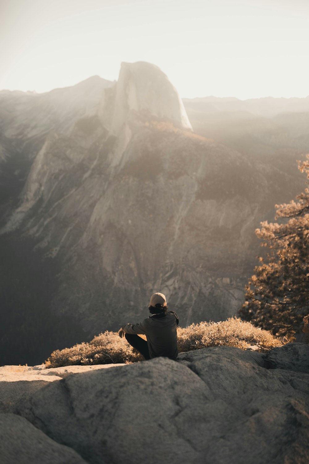 昼間、山の近くの岩の上に座っている人