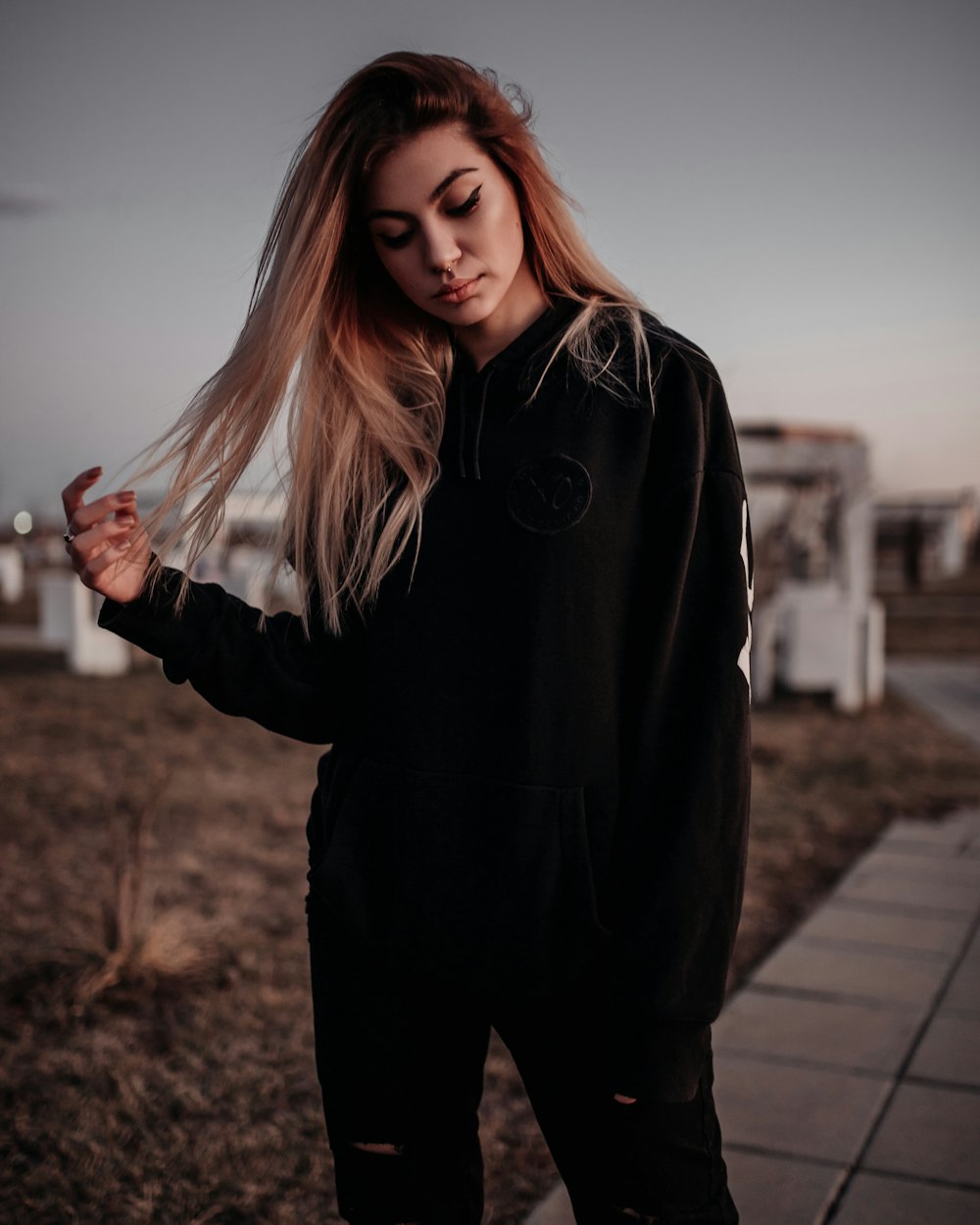 woman in black jacket standing on brown wooden pathway during daytime