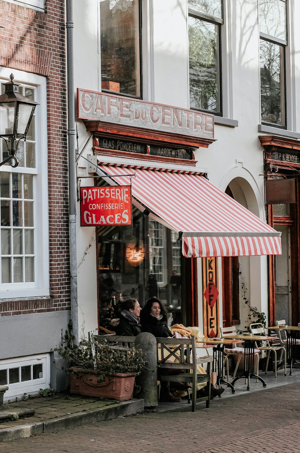 Menschen, die tagsüber auf Stühlen vor dem Restaurant sitzen