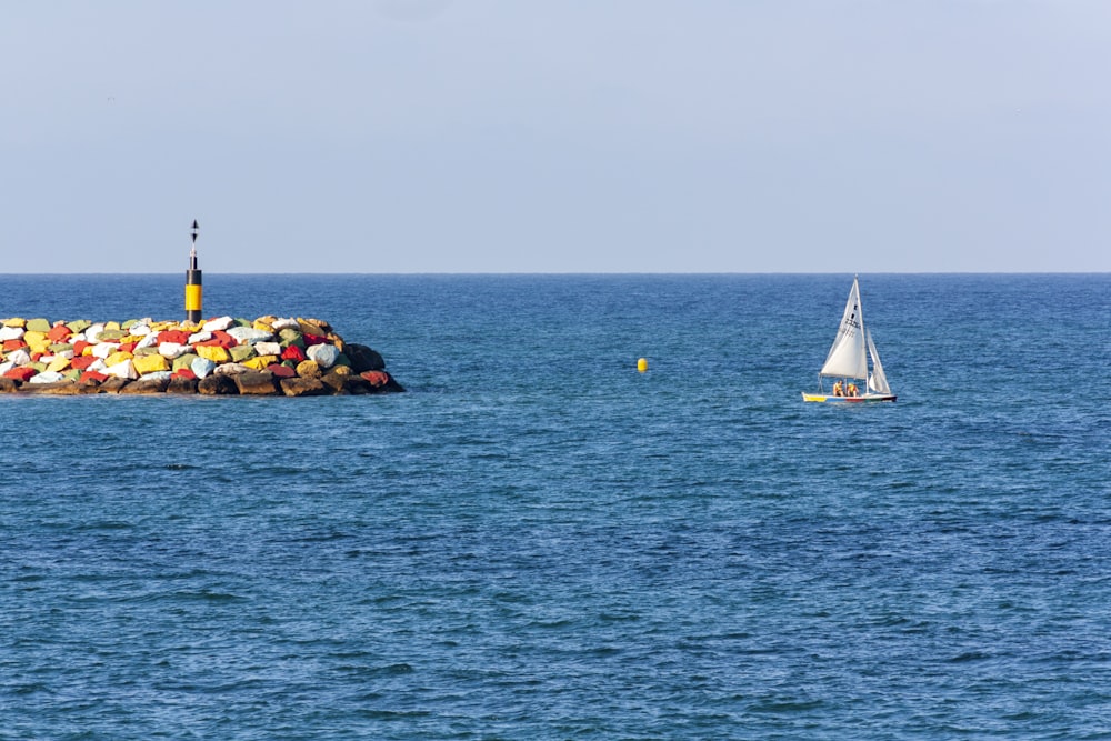 white sail boat on sea during daytime