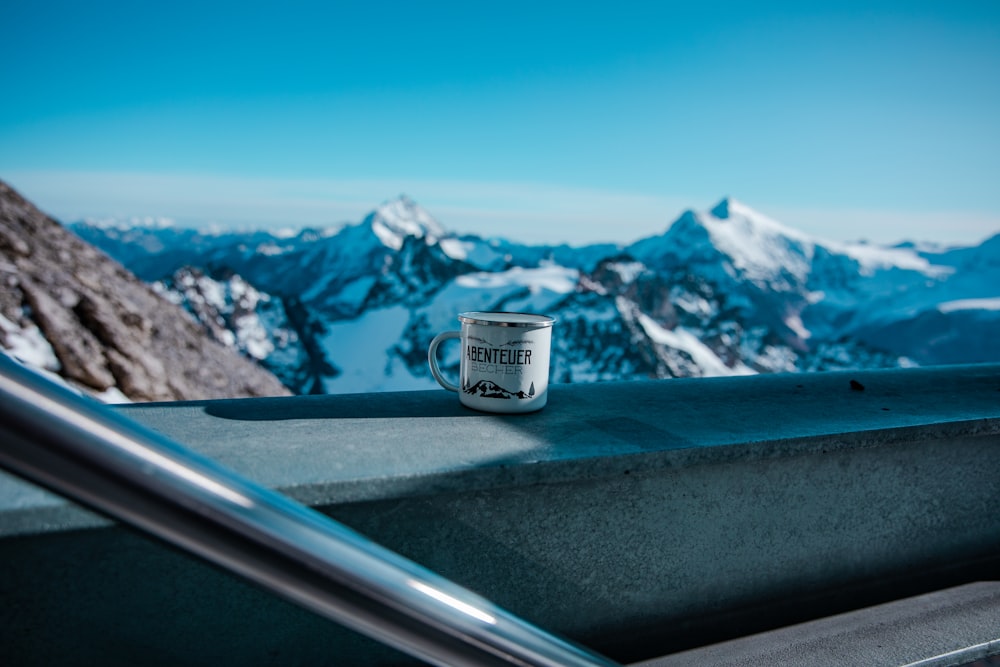 white and black ceramic mug on car dashboard