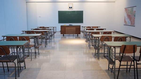 An image of an empty traditional Chinese classroom, with a blank green chalkboard at the front.