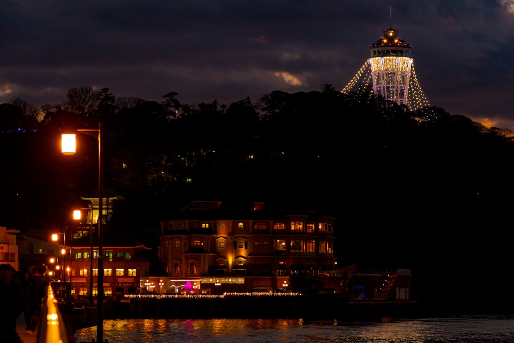 lighted building near body of water during night time