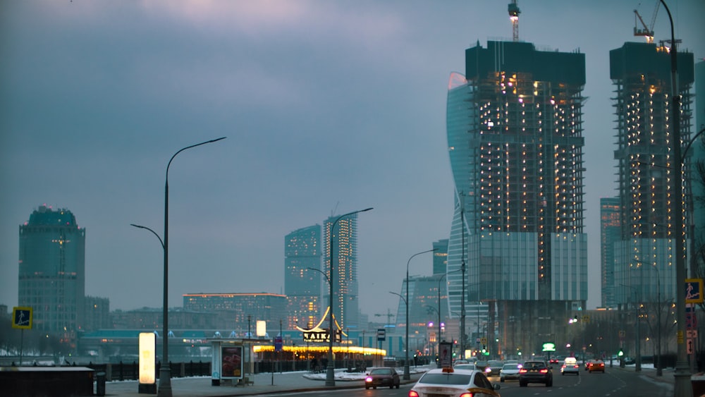 cars on road near high rise buildings during daytime