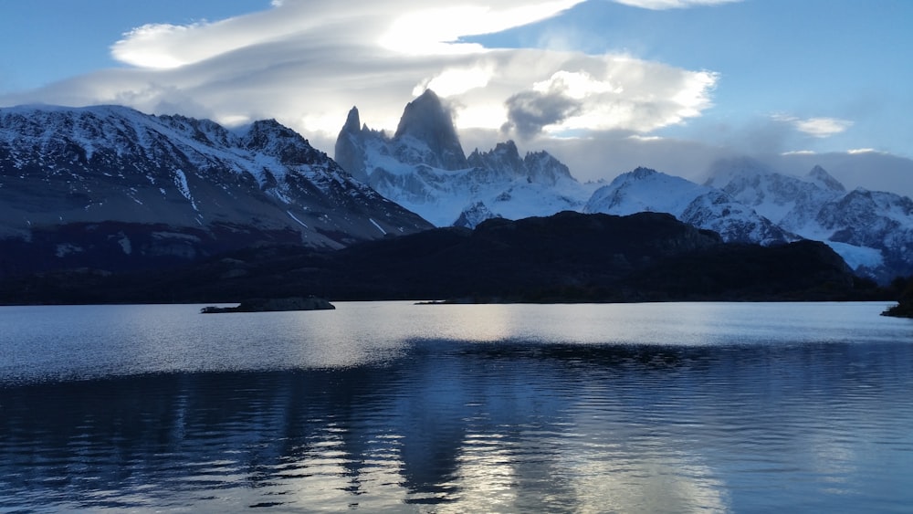 Specchio d'acqua vicino alla montagna innevata durante il giorno