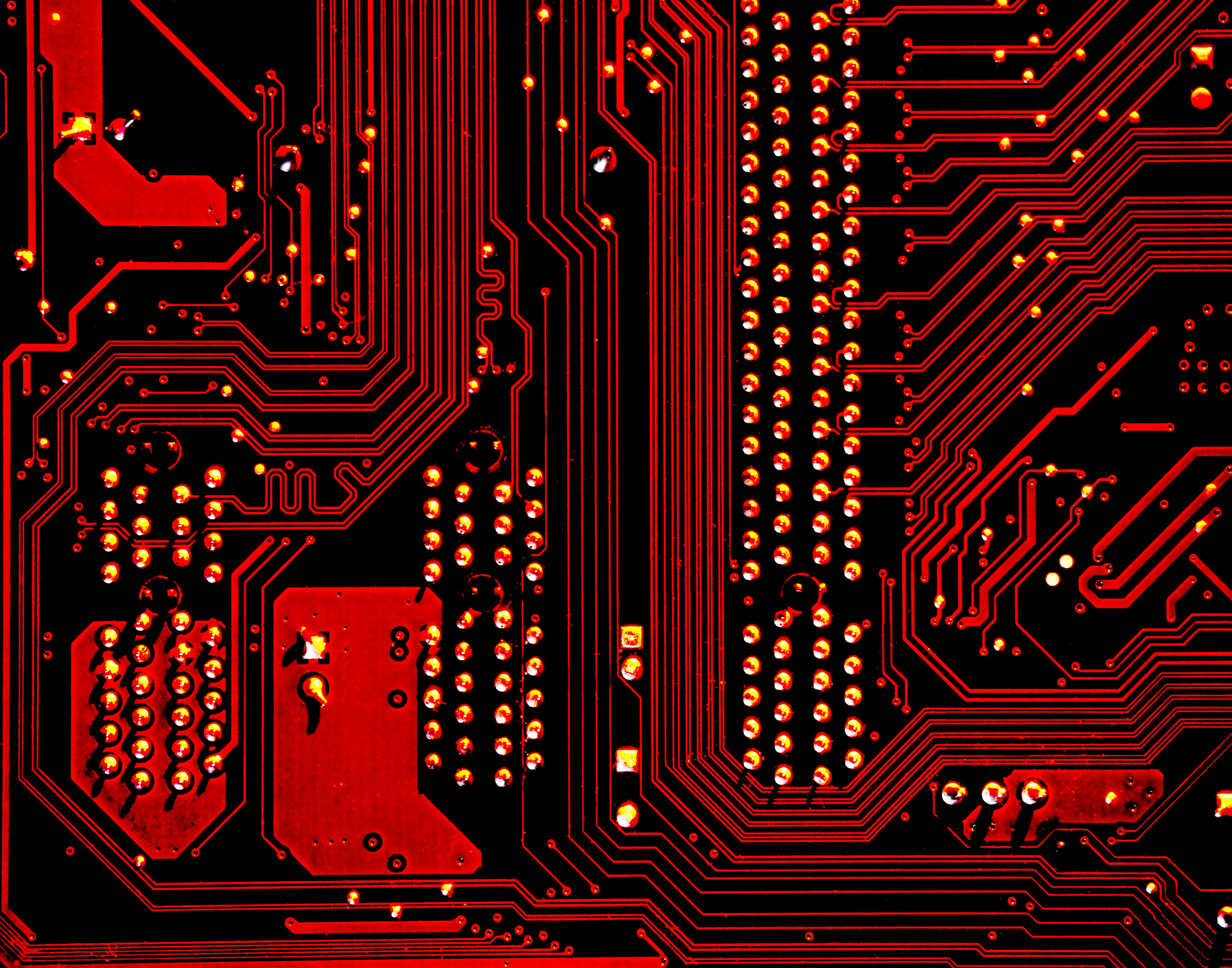 close up of computer microchip circuit board with red lights